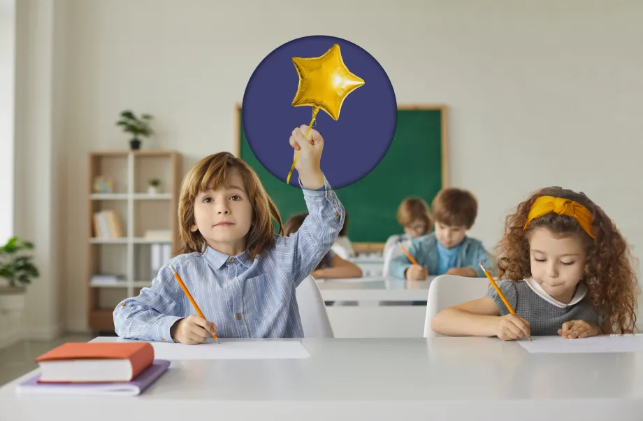 Fotografija djece koja sjede u učionici i pišu. Jedan dječak drži ruku u zraku. Preko njegove ruke je kržnica u kojoj je ilustracija šake koja drži balon u obliku zvijezde na štapiću.