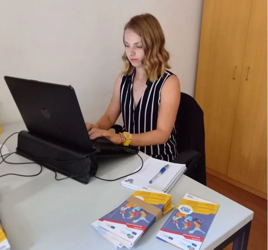 Mlada žena u uredu radi na laptopu