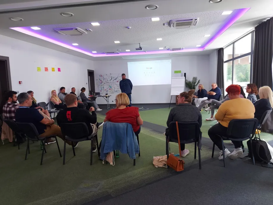 Grupa ljudi sjedi na stolcima posloženim u krug