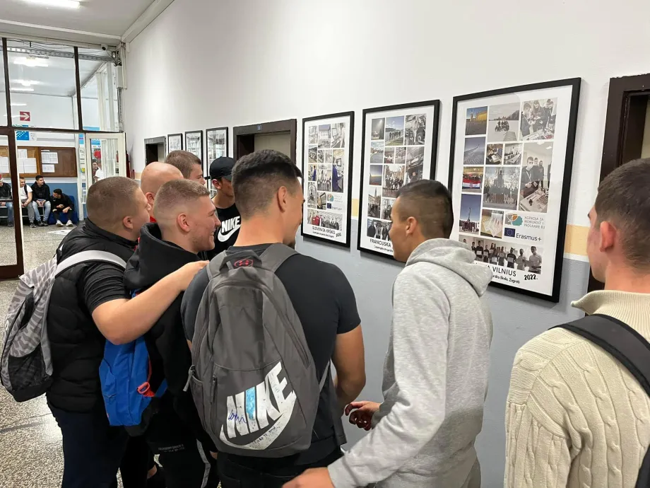Grupa mladića stoji ispred fotografija u hodniku Industrijske strojarske škole