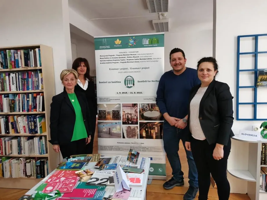 Muškarac i tri žene stoje ispred plakata za Erasmus+ projekt