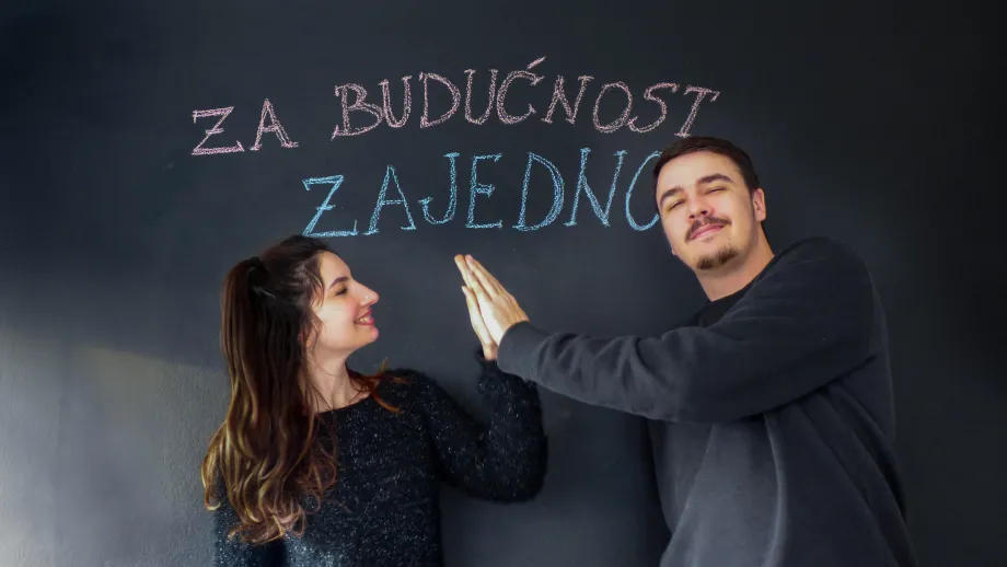 dvoje mladih si međusobno daje pet s rukama