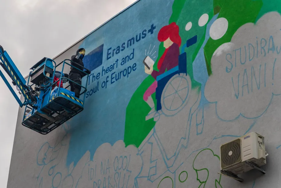 Grafiteri na dizalici oslikavaju Erasmus+ mural na zidu koje dijele dvije osječke strukovne škole