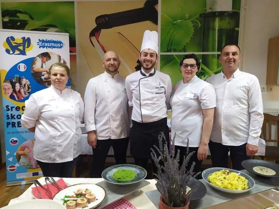 Dvije kuharice i tri kuhara poziraju ispred Erasmus+ plakata