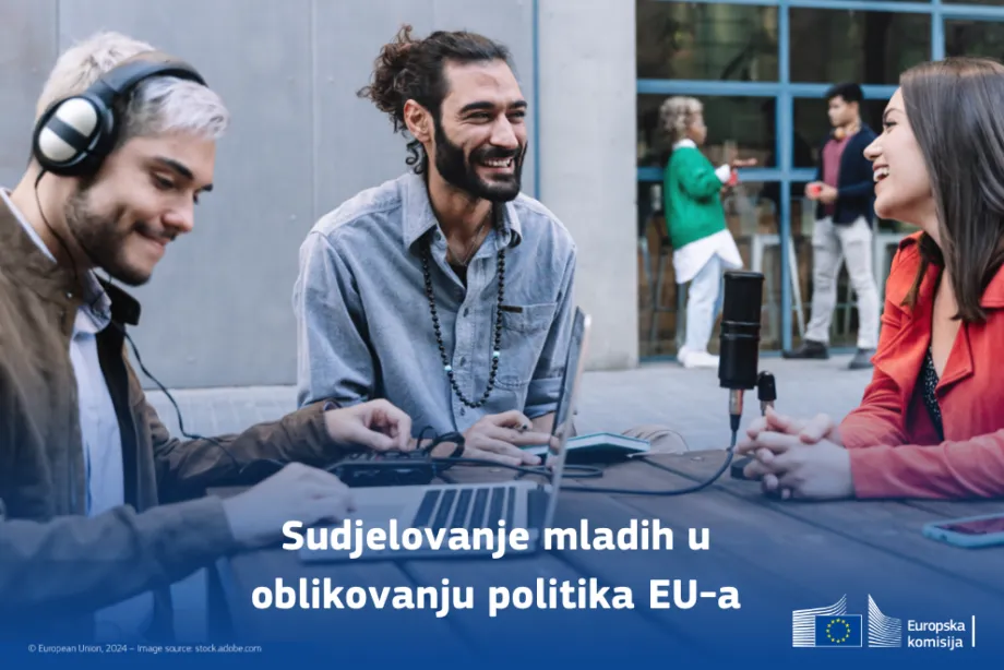 Vizual na kojem se nalaze dva nasmiješena muškarca i žena za stolom. Muškarac sjedi sa slušalicama za laptopom. Drugi muškarac i žena pričaju i smiju se.