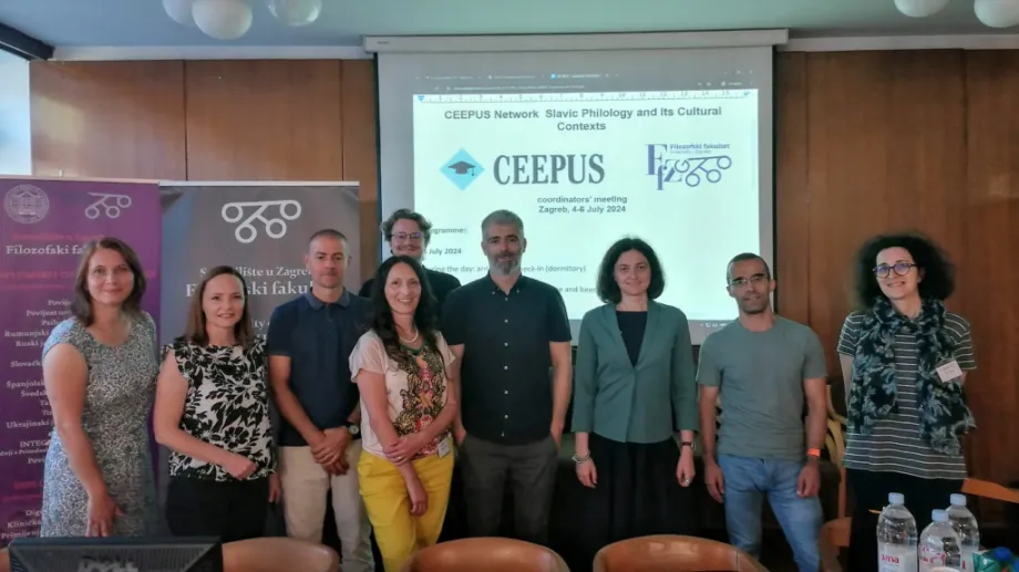 Grupa CEEPUS koordinatora na sastanku stoji ispred platna za projekciju i pozira za fotografiju.