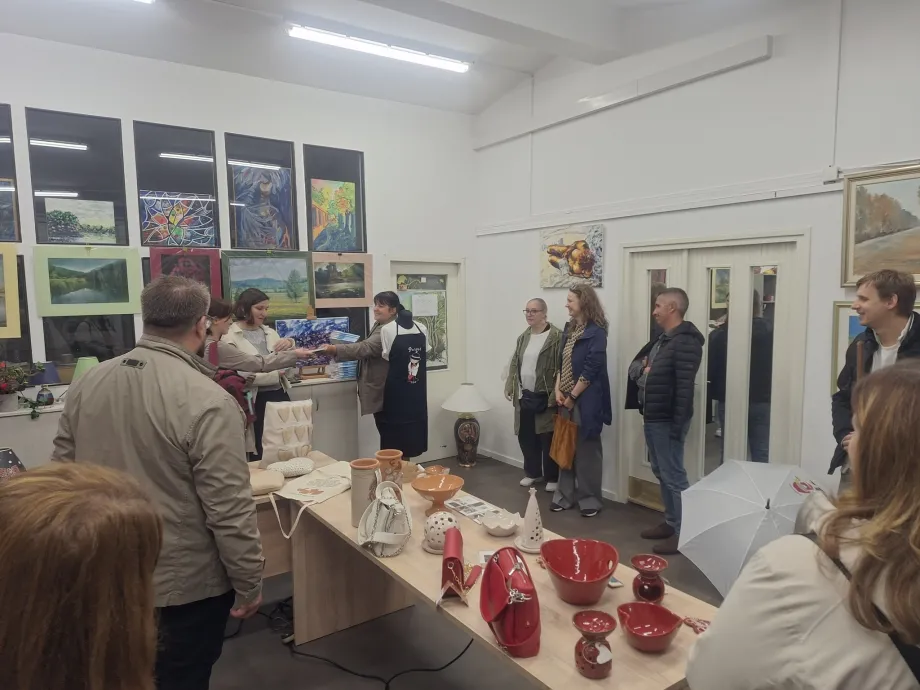 Skupina osoba nalazi se u interijeru Tifološkog muzeja u Zagrebu s taktilnim izlošcima (keramičkim predmetima i slikama) za osobe s oštećenjem vida