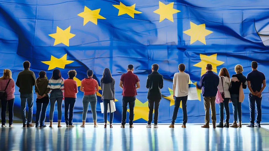 Skupina građana stoji ispred zastave Europske unije